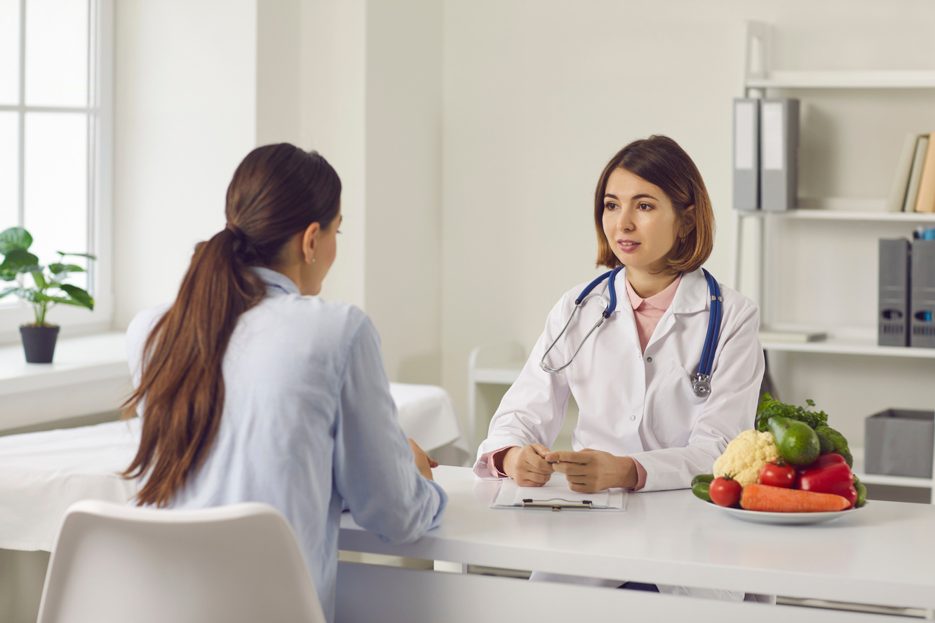 Nutritionist Talking to Young Woman about Health Problems and Making Individual Diet Plan